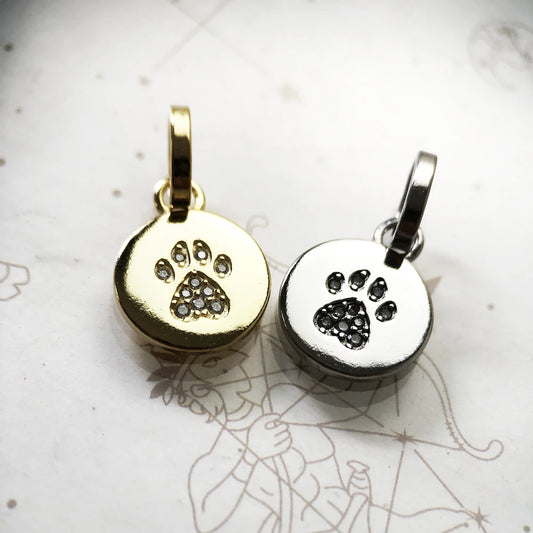 Gold and silver paw print pendants on a light background