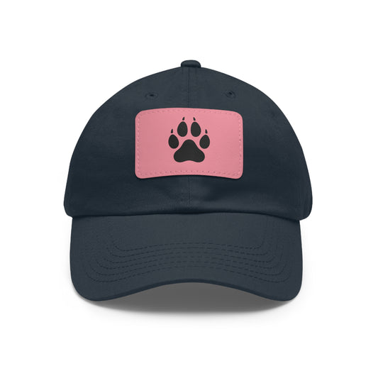 Navy blue cap with a pink patch featuring a black wolf paw print on a white background