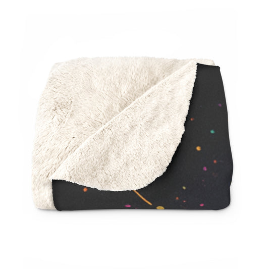 Folded blanket with white fleece on one side and black background with colorful wolf design on the other, on a white background.