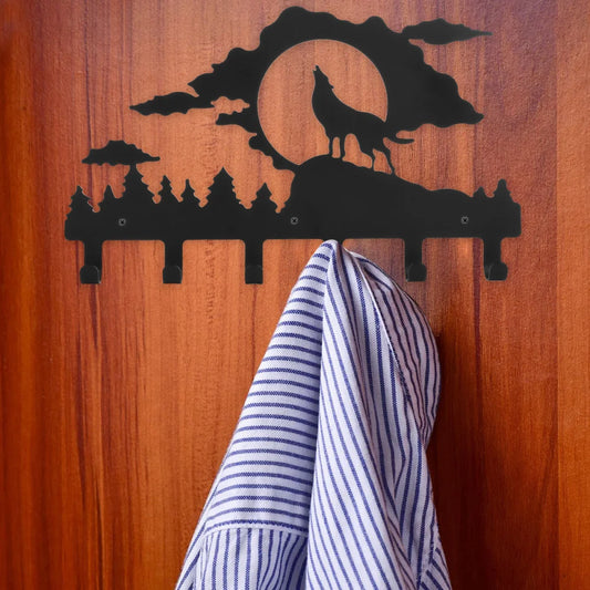 Decorative wall hook with wolf design on a wooden surface with a striped towel hanging on it.
