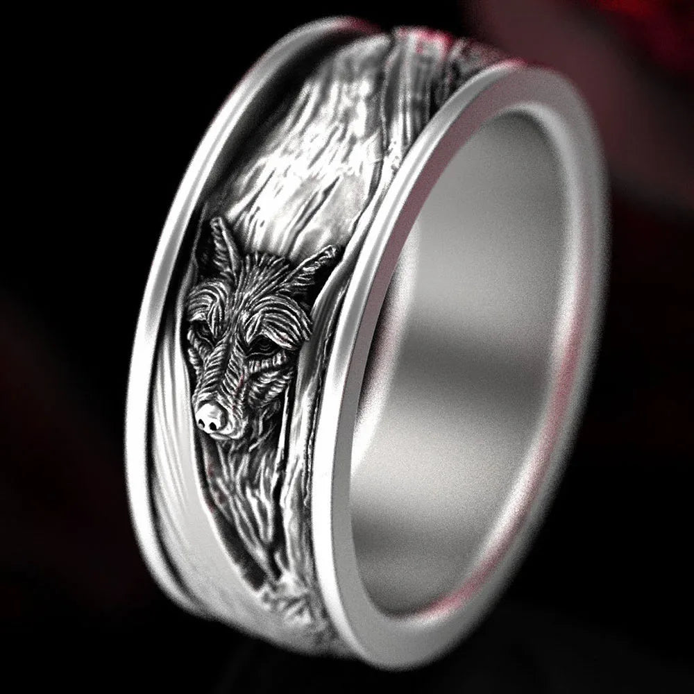 Silver ring with wolf head design on a dark background