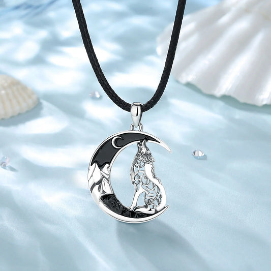 Silver crescent moon pendant with a wolf design on a black cord against a water and shell background.
