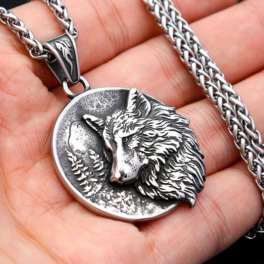Silver wolf pendant necklace held in a hand