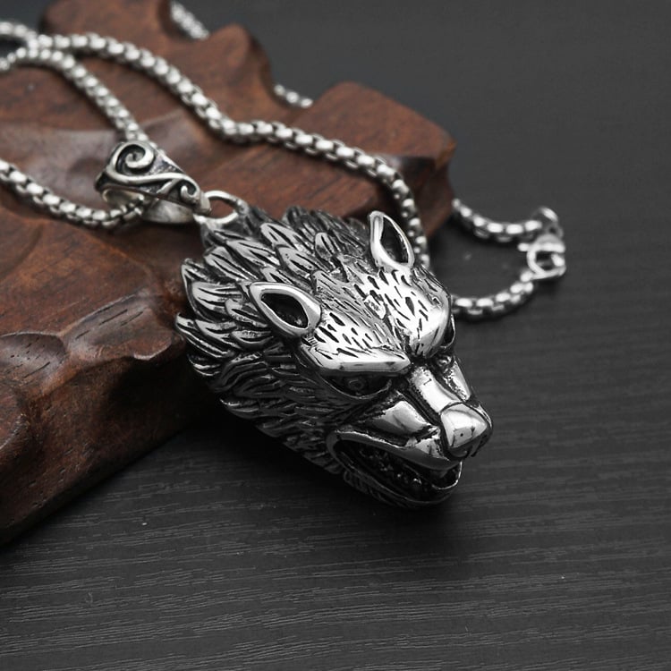 Silver wolf pendant necklace on a dark surface