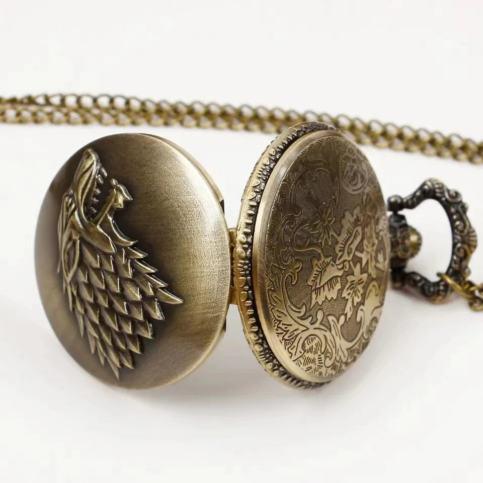 Bronze pocket watch with detailed wolf design on a white background
