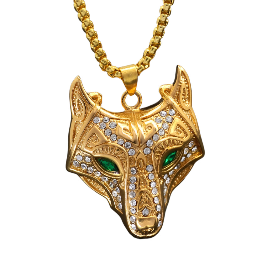 Gold wolf head pendant with green eyes on a black background