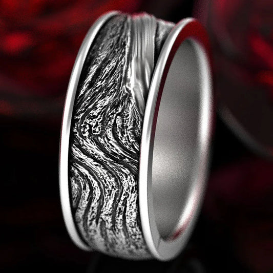 Silver ring with unique texture design on a dark background