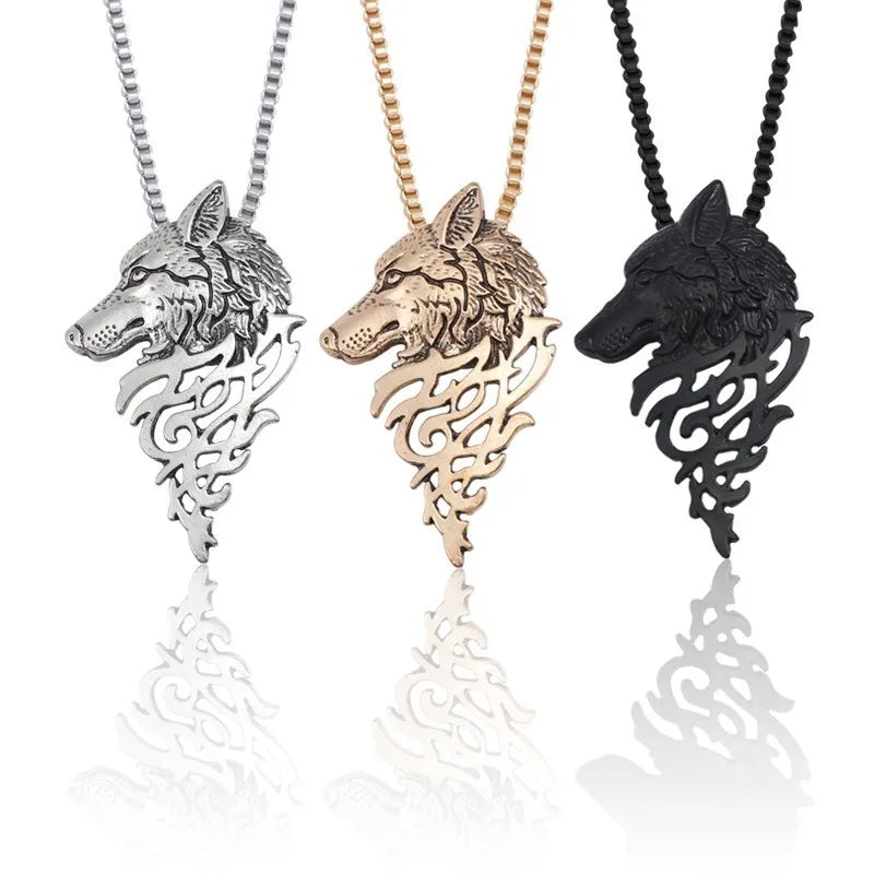 Three wolf head pendants in silver, gold, and black on white background