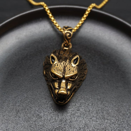Gold wolf head pendant on a black background