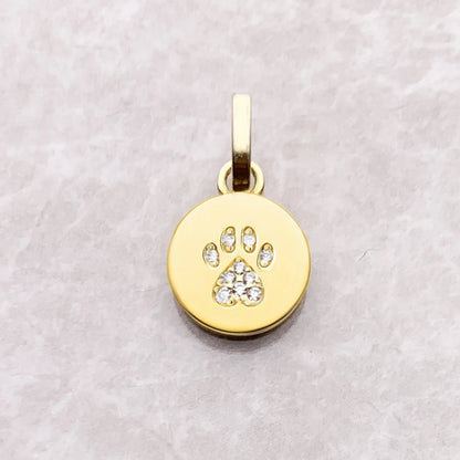 Gold pendant with paw print design on a light gray background