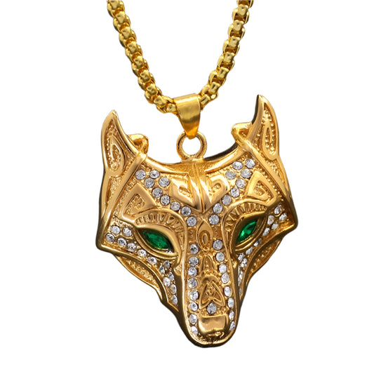Gold wolf head pendant with green eyes on a black background