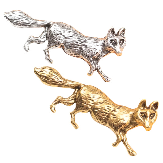 Two fox-shaped pins, one gold and one silver, on a white background.