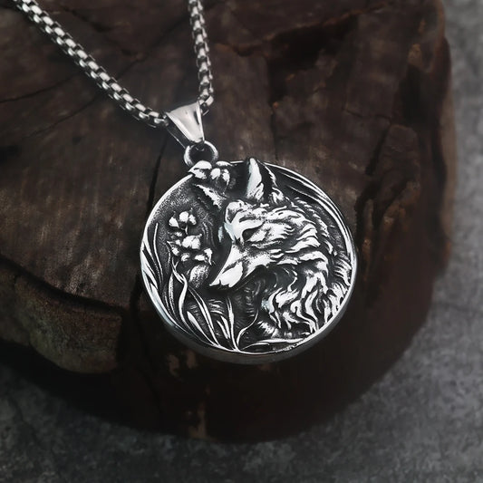 Silver pendant with wolf design on a dark background