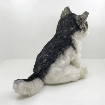 Plush toy resembling a gray and white wolf on a white background