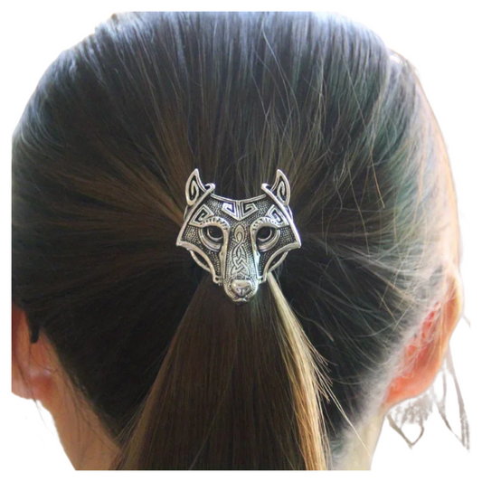 Silver wolf head hair clip on a person's hair against a white background