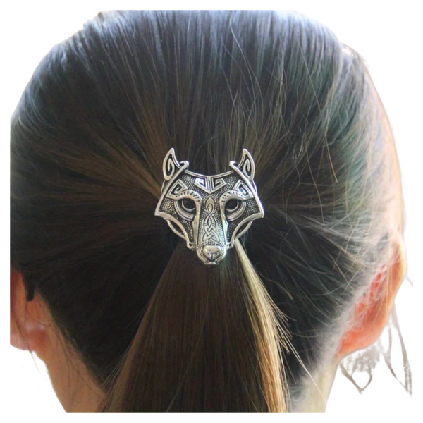 Silver wolf head hair clip on a person's hair against a white background